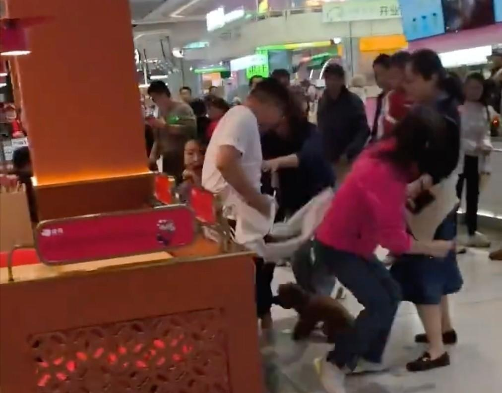 狗闯入店内欲咬人 男子拿板凳反击